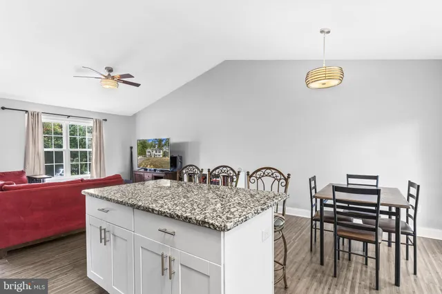 a kitchen with a table chairs and wooden floor