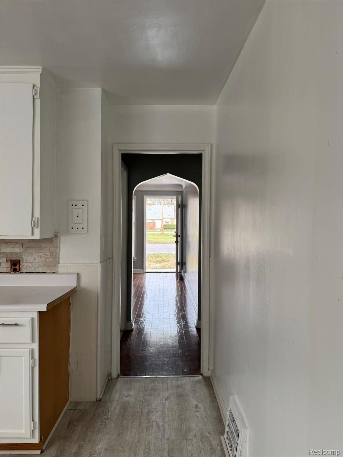 19706 Moross Road Detroit, MI 48224 - Photo 5 of 13 Kitchen area with white cabinetry, light countertops, and a partial tile backsplash