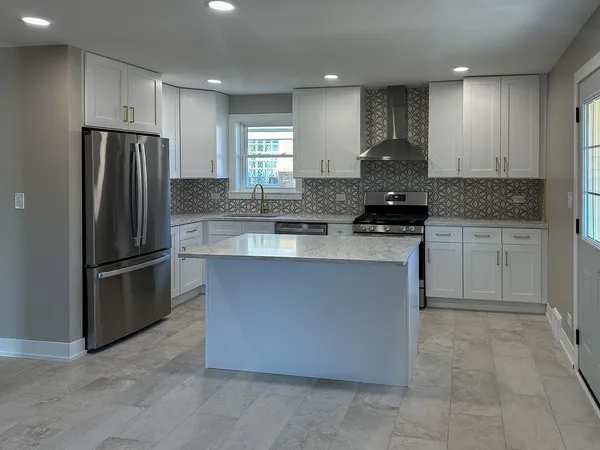 a kitchen with stainless steel appliances granite countertop a refrigerator a sink a stove a microwave and island