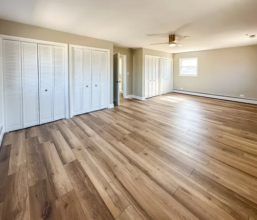 a view of an empty room with wooden floor