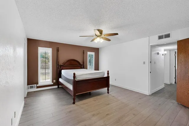a bedroom with a bed and a ceiling fan