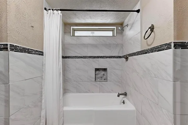 a bathroom with a bathtub and a shower
