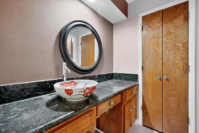 a bathroom with a granite countertop sink and a mirror