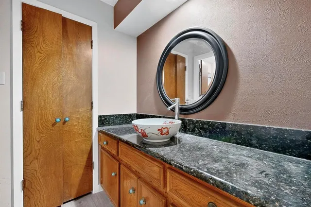 a bathroom with a granite countertop sink and a mirror