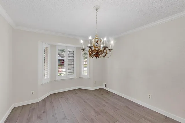 a view of a room with wooden floor and chandelier