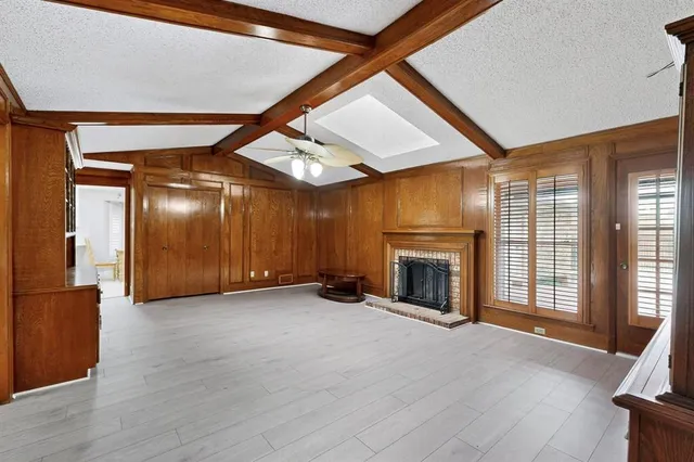 a view of an empty room with a fireplace and a window