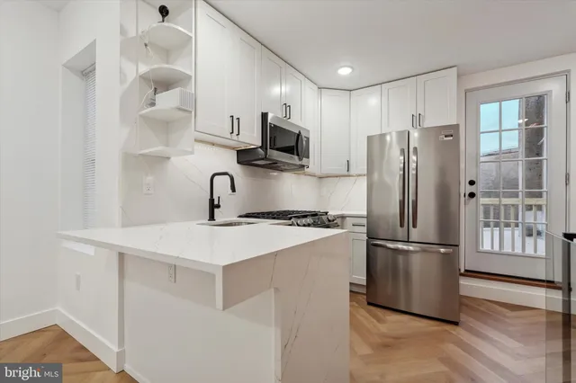 a kitchen with stainless steel appliances a refrigerator sink and microwave