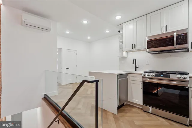 a kitchen with stainless steel appliances a stove microwave and sink