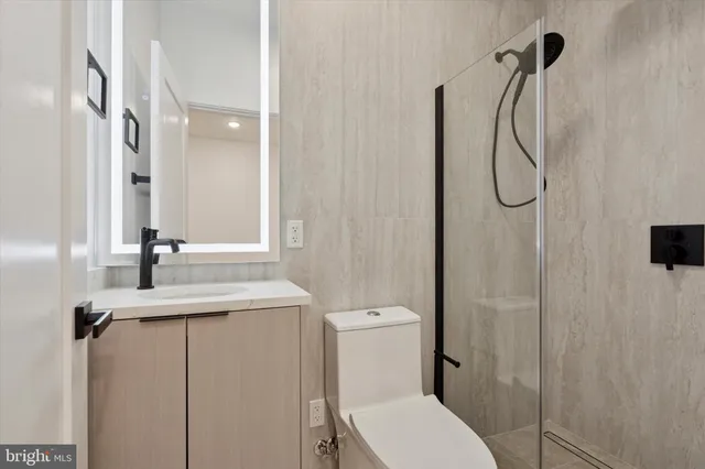 a bathroom with a granite countertop sink toilet and shower
