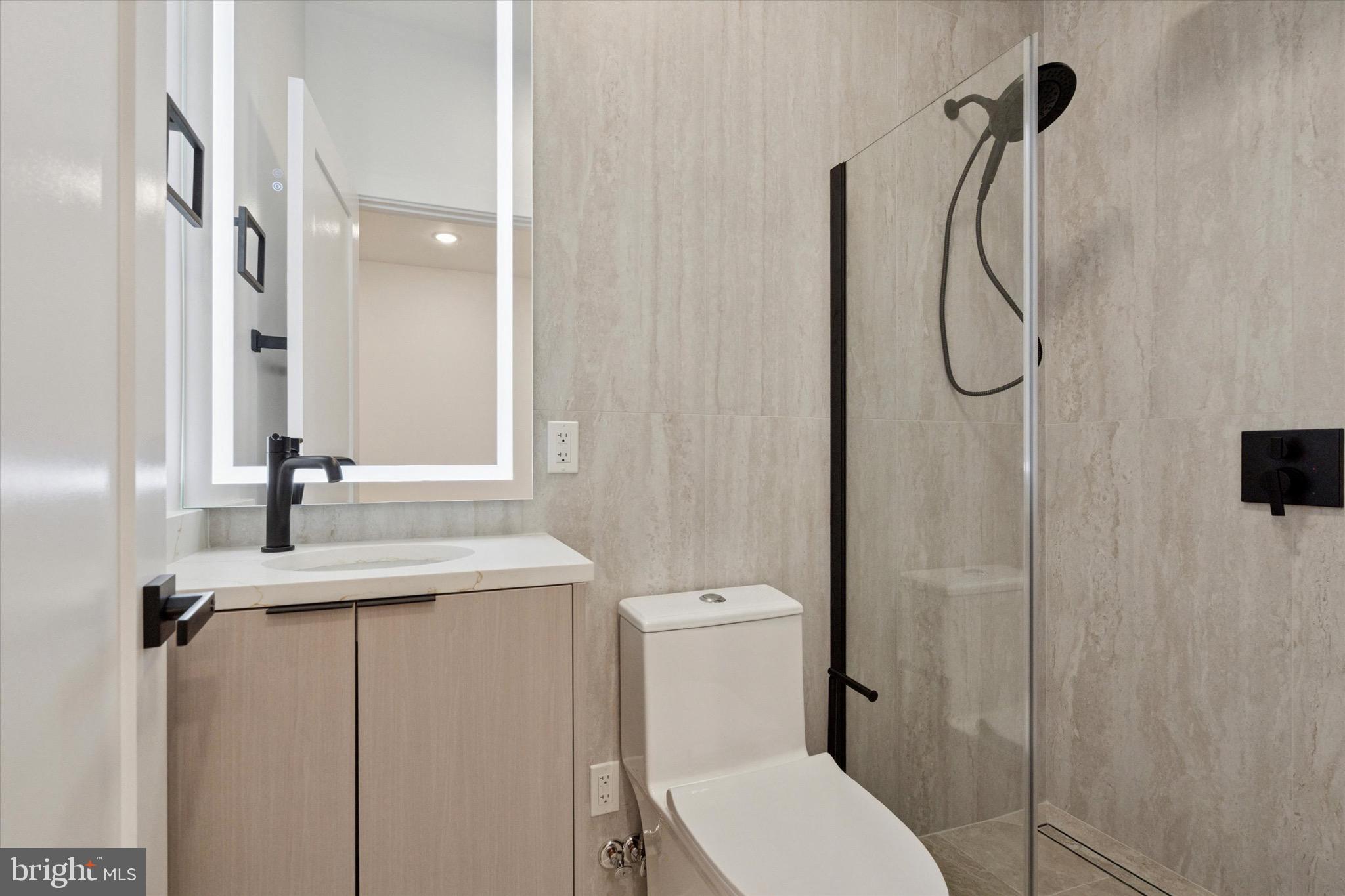 1438 Tasker Street, Unit 3 Philadelphia, PA 19145 - Photo 3 of 9 a bathroom with a granite countertop sink toilet and shower