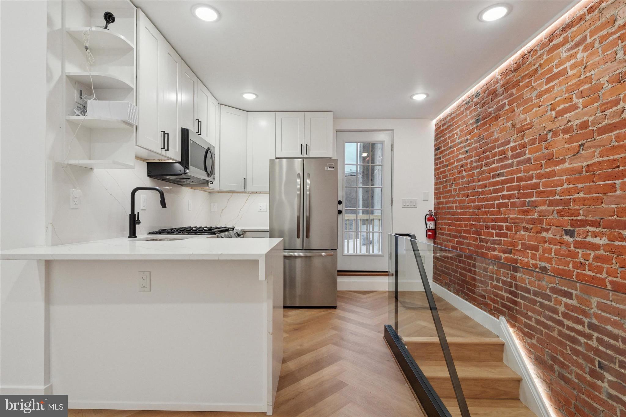 1438 Tasker Street, Unit 3 Philadelphia, PA 19145 - Photo 4 of 9 a kitchen with stainless steel appliances granite countertop a sink and a refrigerator
