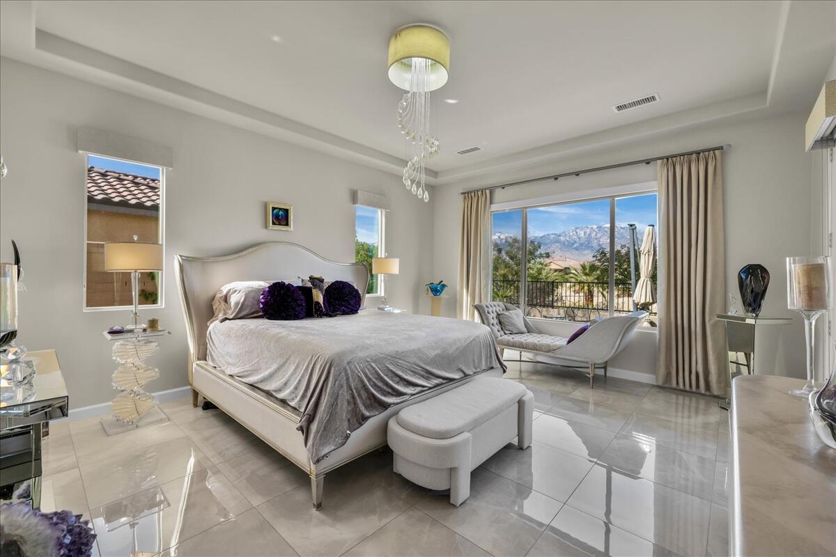 100 Barolo Rancho Mirage, CA 92270 - Photo 24 of 38 a bedroom with a bed and a chandelier