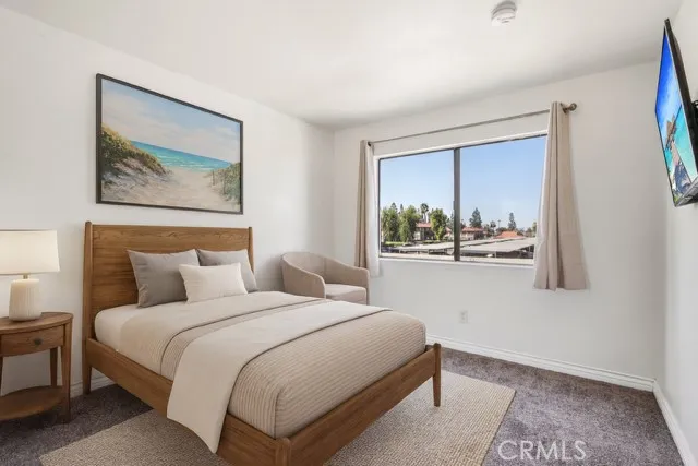 a bedroom with a bed and a painting on the wall