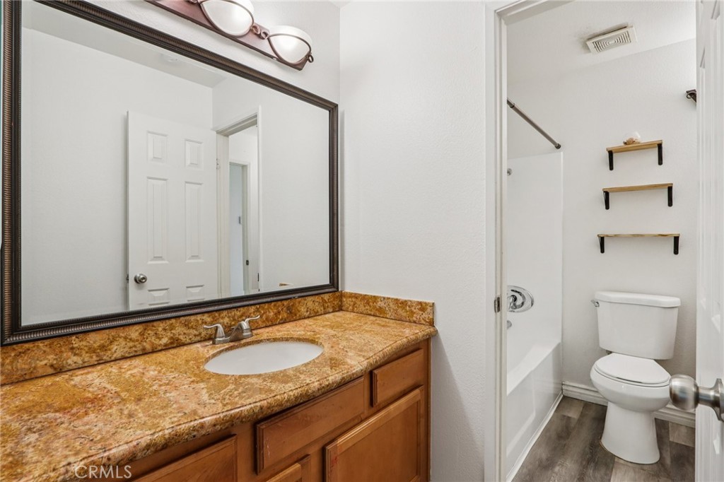 1142 West Blaine Street, Unit 201 Riverside, CA 92507 - Photo 16 of 24 a bathroom with a granite countertop sink and a toilet