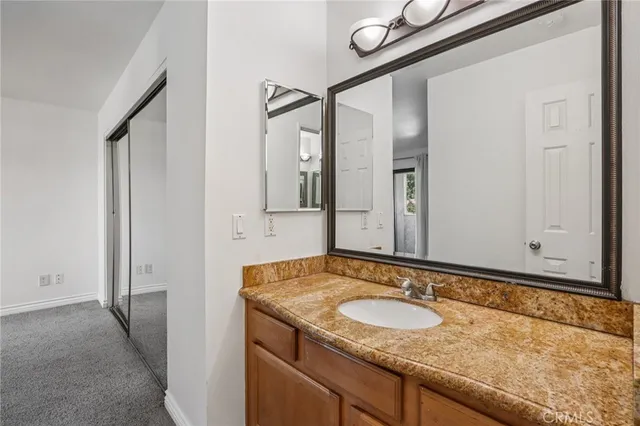 a bathroom with a granite countertop sink and a mirror