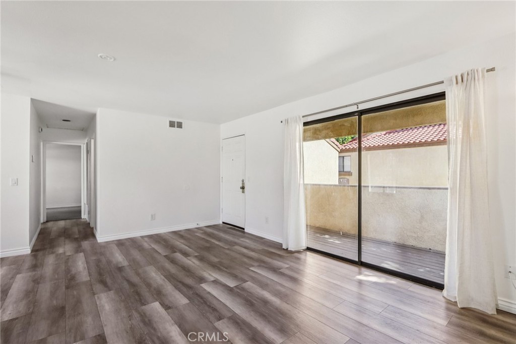 1142 West Blaine Street, Unit 201 Riverside, CA 92507 - Photo 9 of 24 a view of an empty room and wooden floor