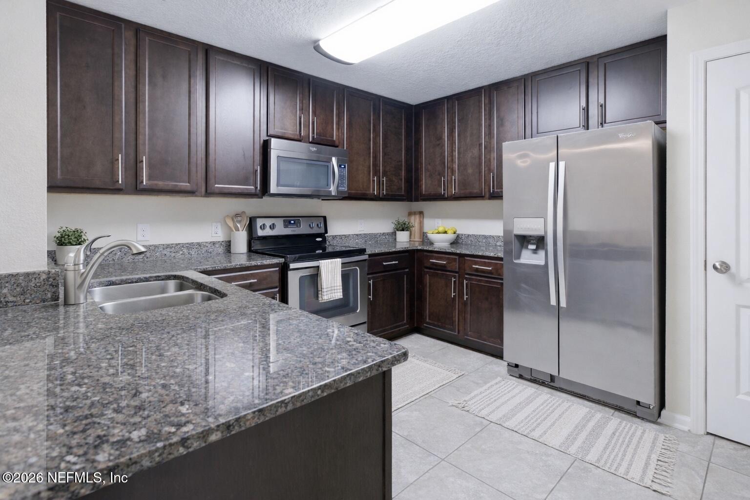821 Golden Lake Loop St. Augustine, FL 32084 - Photo 6 of 27 a kitchen with stainless steel appliances granite countertop a sink a stove a refrigerator and cabinets