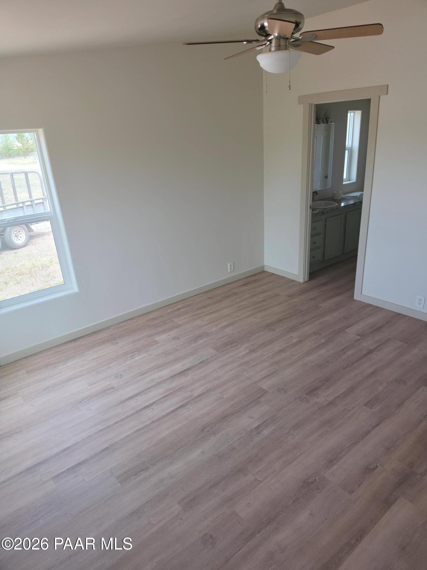 23525 North Ropers Lane Paulden, AZ 86334 - Photo 12 of 25 an empty room with wooden floor cabinet and windows