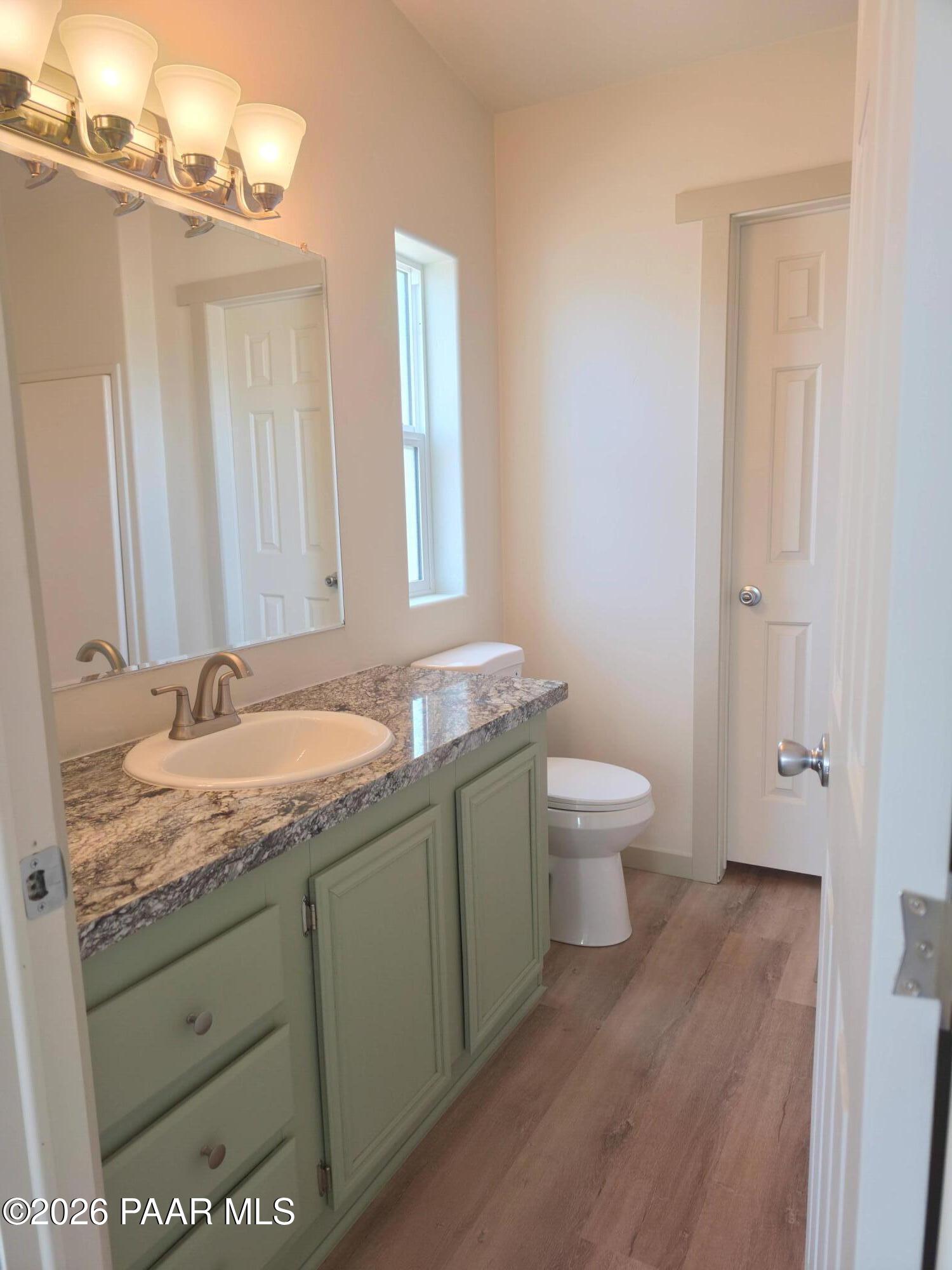 23525 North Ropers Lane Paulden, AZ 86334 - Photo 14 of 25 a bathroom with a granite countertop sink a toilet and a mirror