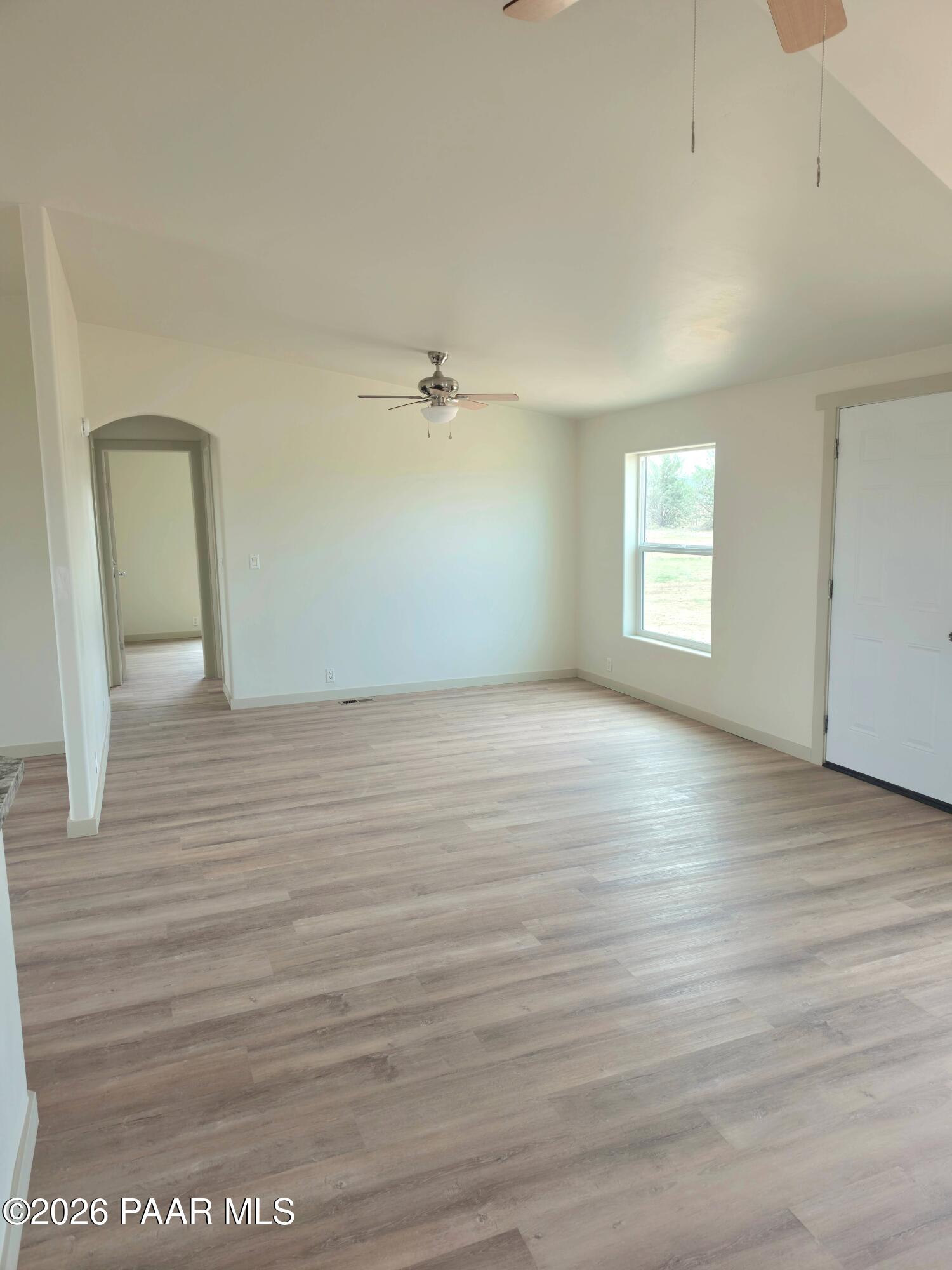 23525 North Ropers Lane Paulden, AZ 86334 - Photo 3 of 25 a view of an empty room with wooden floor and a window