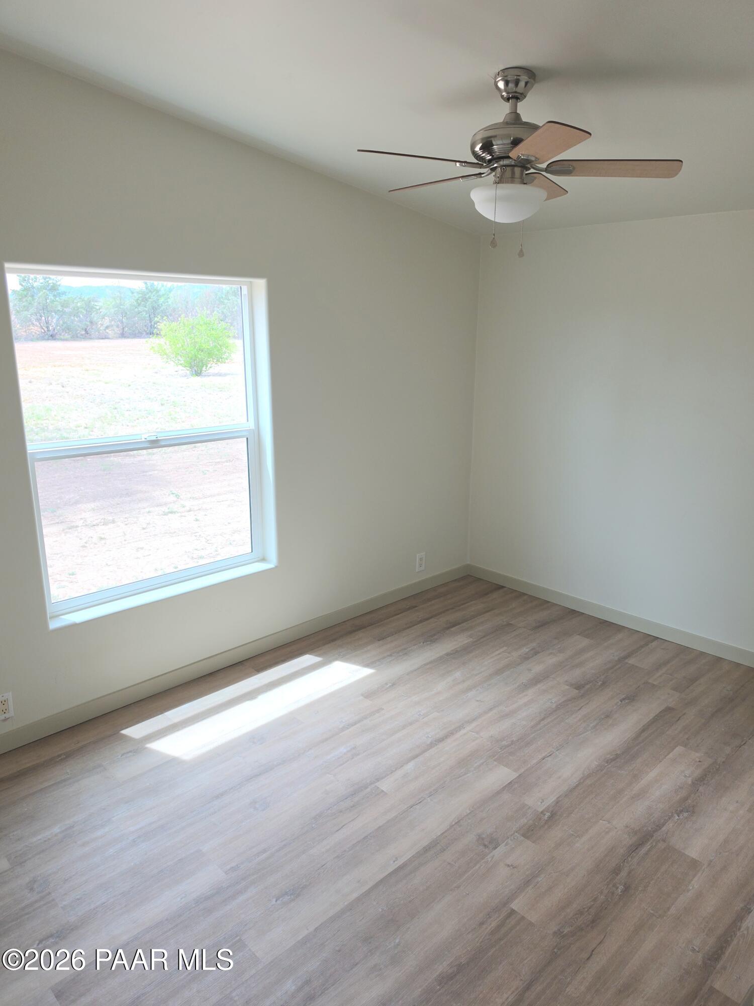 23525 North Ropers Lane Paulden, AZ 86334 - Photo 8 of 25 an empty room with a window and a fan