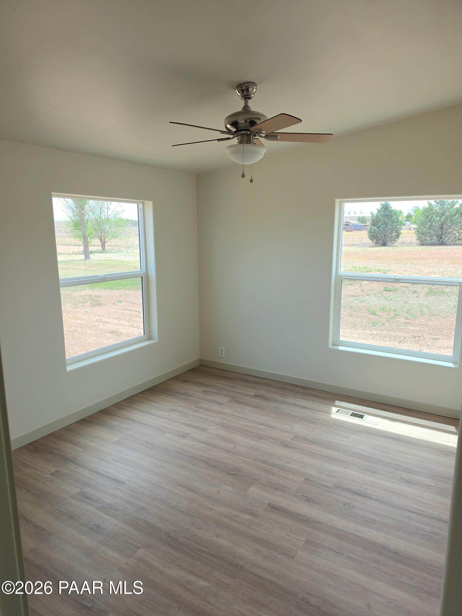 23525 North Ropers Lane Paulden, AZ 86334 - Photo 9 of 25 a view of an empty room with wooden floor and a window