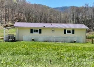 1638 Hughes Gap Road Bakersville, NC 28705 - Photo 3 of 12 a view of a house with a yard and a large tree