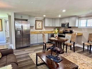 1638 Hughes Gap Road Bakersville, NC 28705 - Photo 7 of 12 a kitchen with stainless steel appliances kitchen island granite countertop a dining table chairs refrigerator and sink