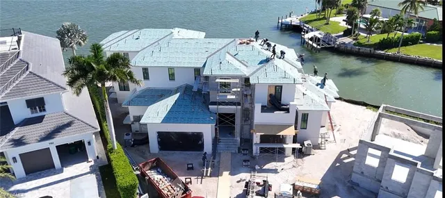 an aerial view of a house with swimming pool and outdoor seating