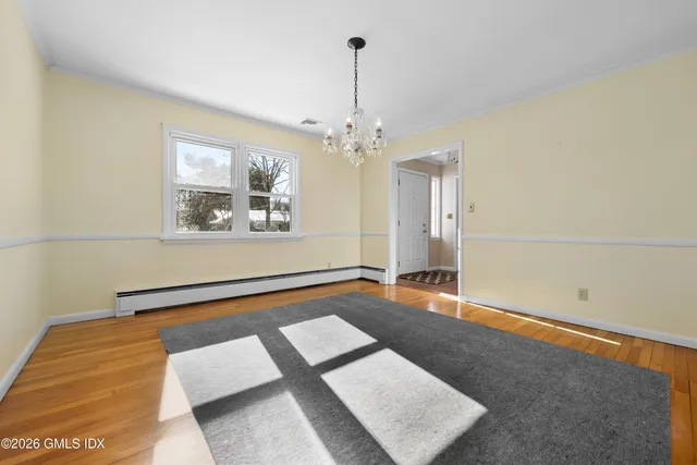 a living room with furniture and a kitchen with wooden floor