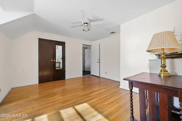 a view of an empty room with a window and wooden floor