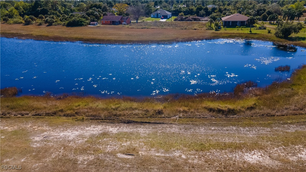 720 Chavers Street East Lehigh Acres, FL 33974 - Photo 12 of 35 a view of a lake with a yard