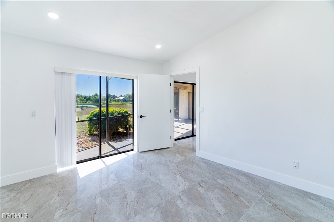 720 Chavers Street East Lehigh Acres, FL 33974 - Photo 23 of 35 an empty room with floor to ceiling window and an entryway