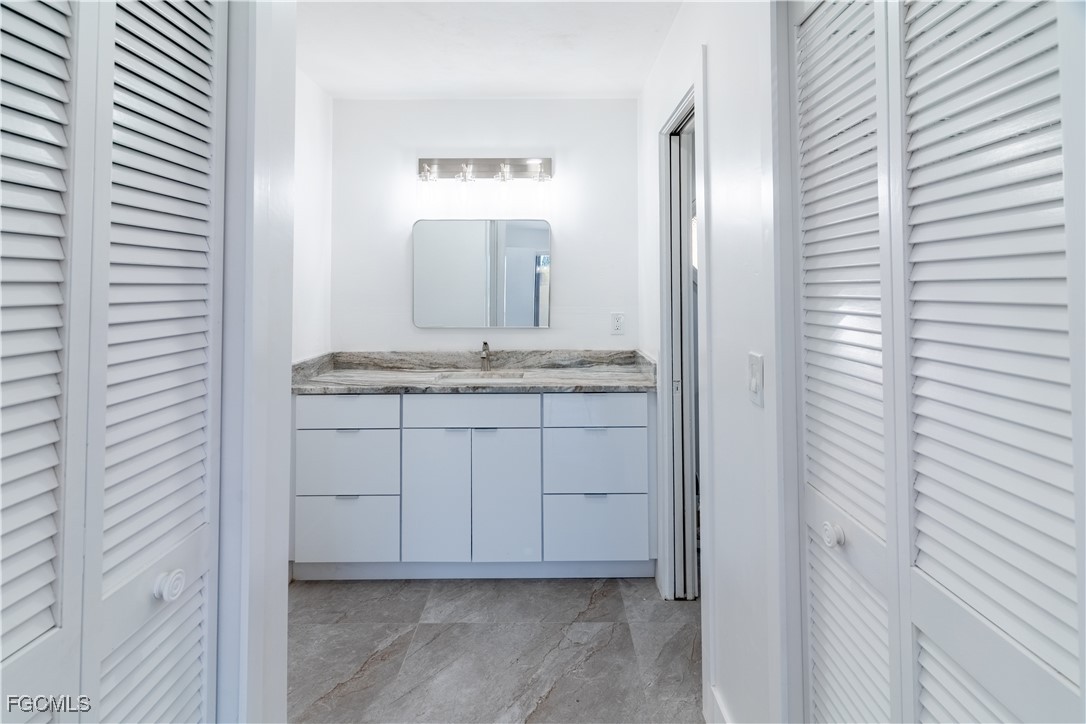 720 Chavers Street East Lehigh Acres, FL 33974 - Photo 34 of 35 a bathroom with a granite countertop sink and a mirror