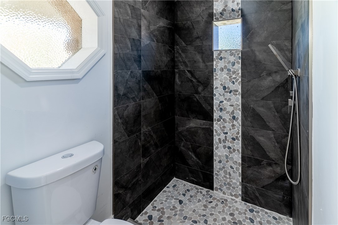 720 Chavers Street East Lehigh Acres, FL 33974 - Photo 9 of 35 a bathroom with a toilet and a shower