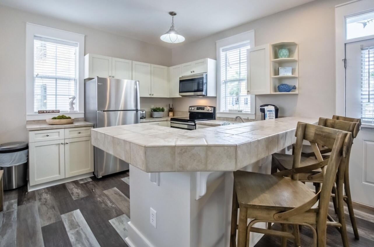 198 Somerset Bridge Road, Unit 141 Santa Rosa Beach, FL 32459 - Photo 9 of 31 a kitchen with stainless steel appliances granite countertop a table chairs sink refrigerator and microwave