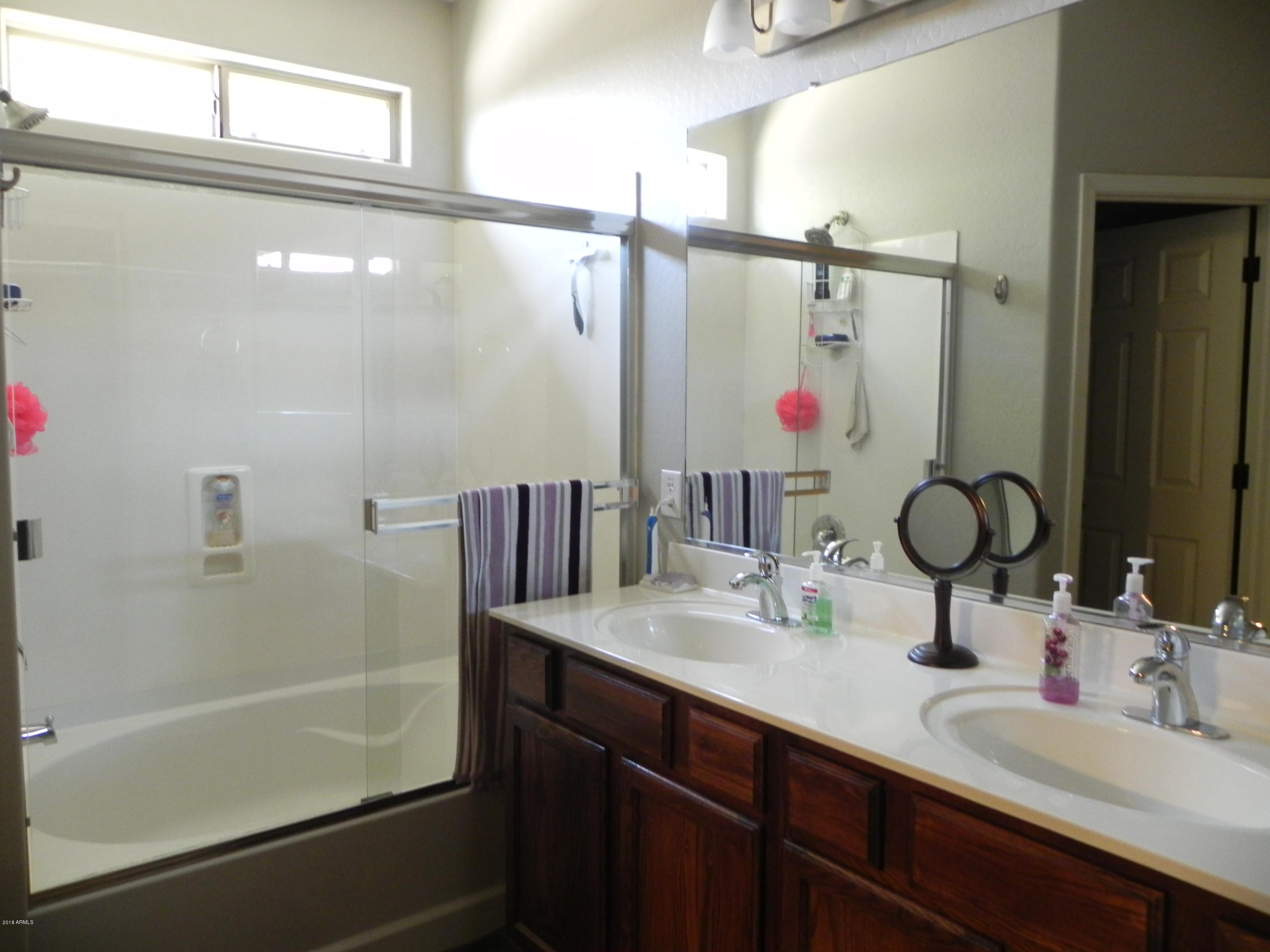 18005 West Hatcher Road Waddell, AZ 85355 - Photo 8 of 18 a bathroom with a sink vanity and a mirror