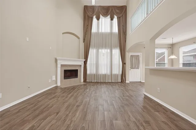 an empty room with wooden floor and a fireplace