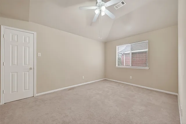 an empty room with a chandelier fan
