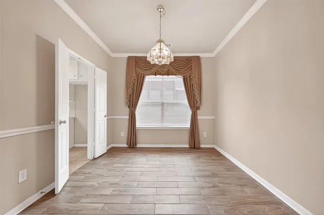 an empty room with wooden floor door and windows