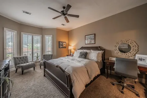 a bedroom with a bed a couch and a dresser next to a window