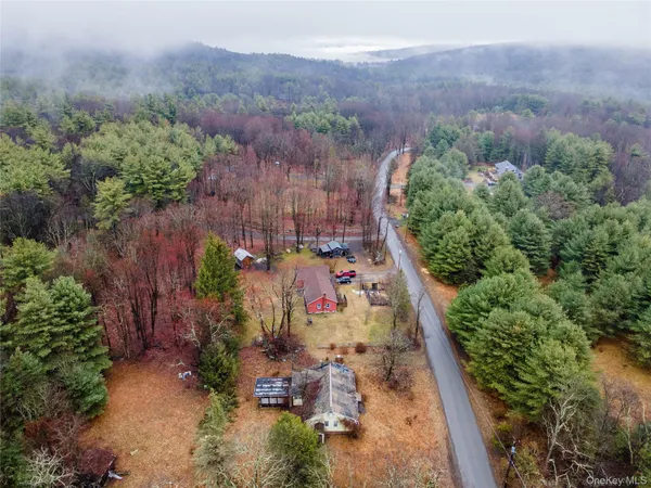 an aerial view of a house with a yard and mountain view in back