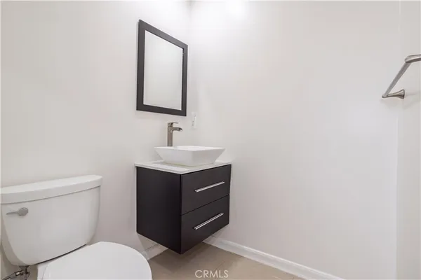 a bathroom with a toilet sink vanity and mirror