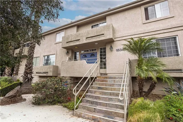 a view of a house with large windows and more plants