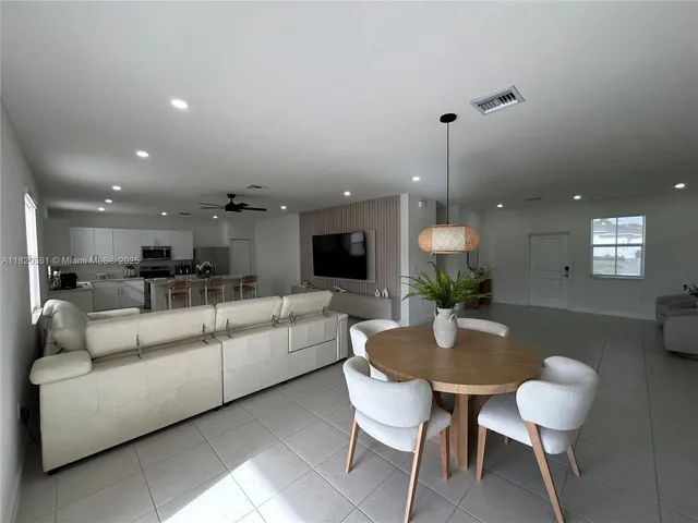 a dining room with furniture and a potted plant