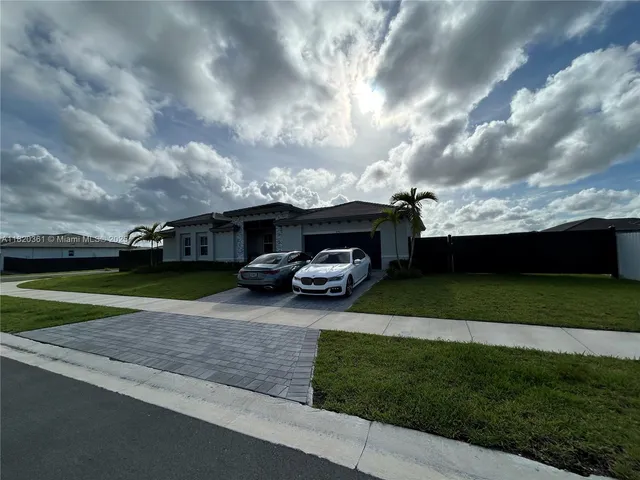 a car parked in front of a house next to a yard