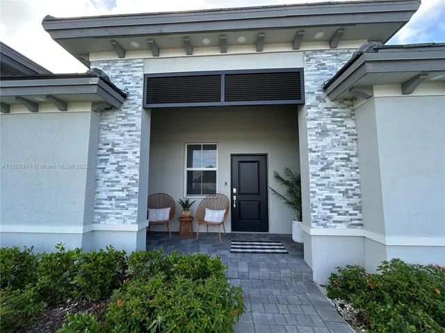 a view of a hallway with furniture and a potted plant