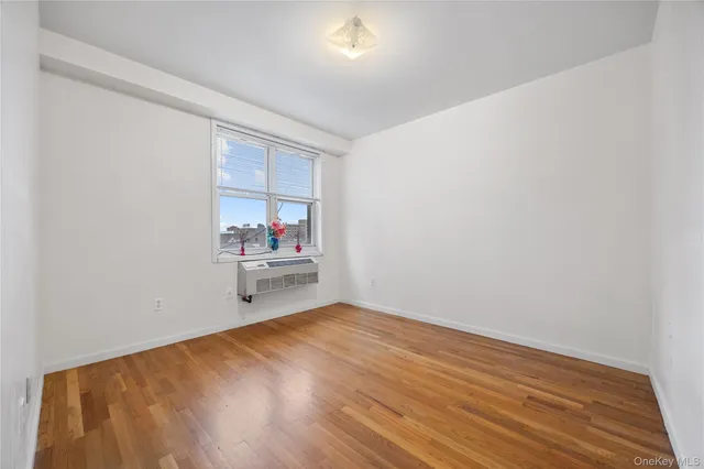 a view of a room with wooden floor and a window