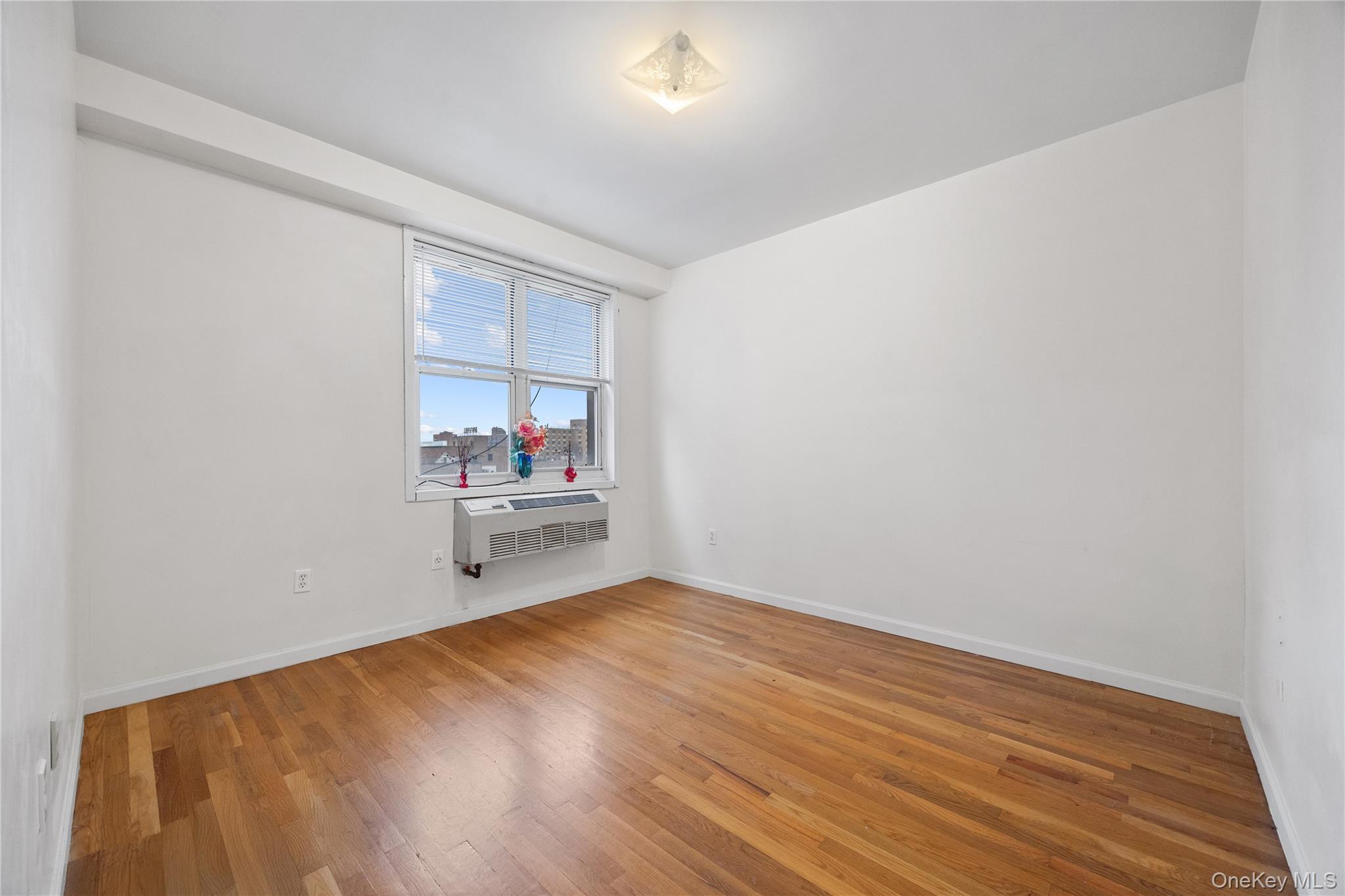 134-38 35th Avenue, Unit 3D Queens, NY 11354 - Photo 10 of 18 a view of a room with wooden floor and a window