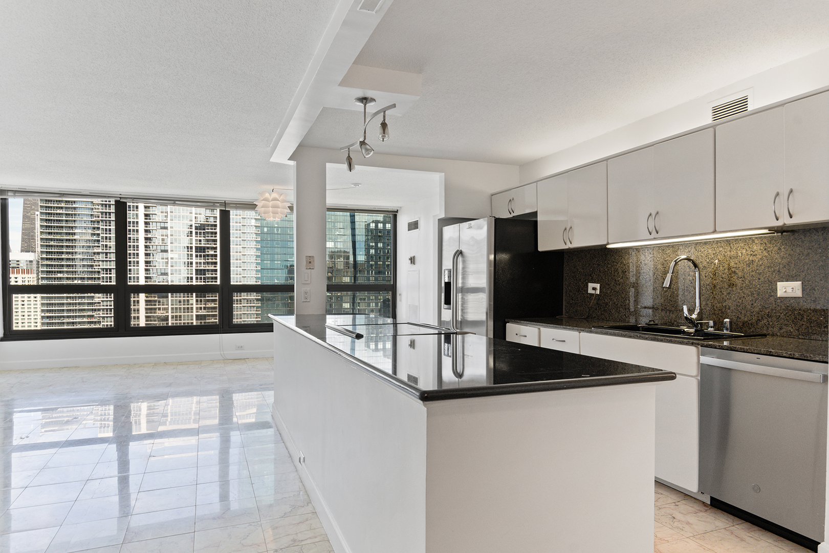 360 East Randolph Street, Unit 3105 Chicago, IL 60601 - Photo 5 of 28 a kitchen with granite countertop a sink and a refrigerator